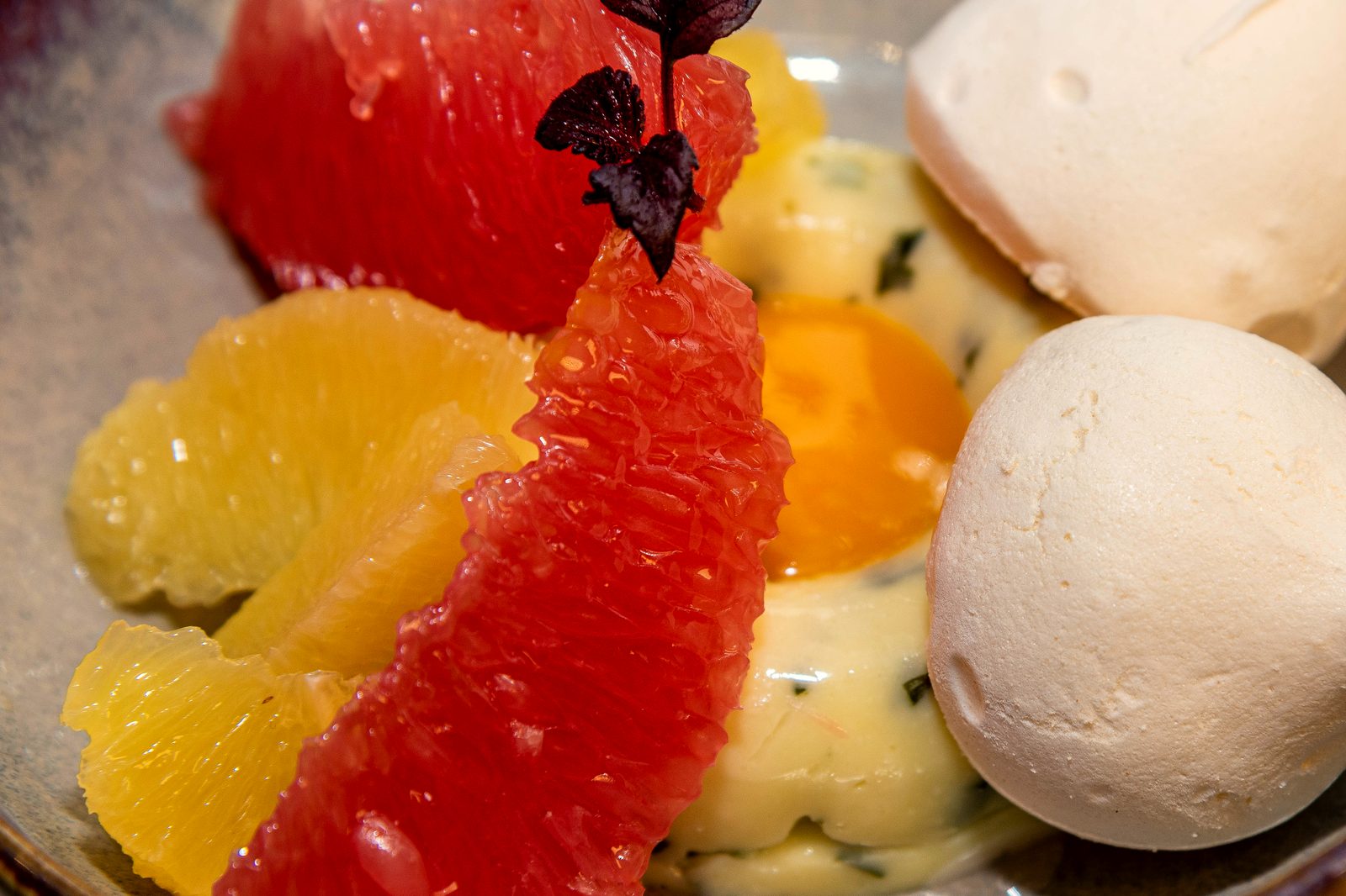 Dessert aux agrumes de L’Apibo : suprêmes de pamplemousse et d’orange, crémeux au citron et meringues blanches dans un bol de grès, quartier Montorgueil à Paris