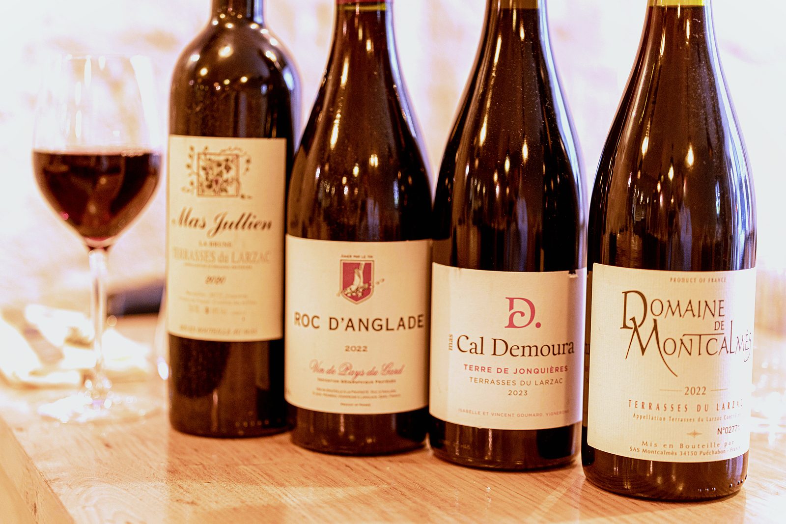Quatre rouges du Languedoc et un verre de vin sur le comptoir de L’Apibo, Paris 2e : Mas Jullien, Roc d’Anglade, Mas Cal Demoura et Domaine de Montcalmès, Terrasses du Larzac